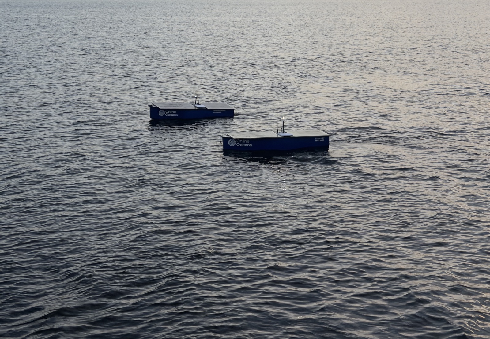 Two Scout USV autonomous surface vehicles on station collecting ocean data at dusk