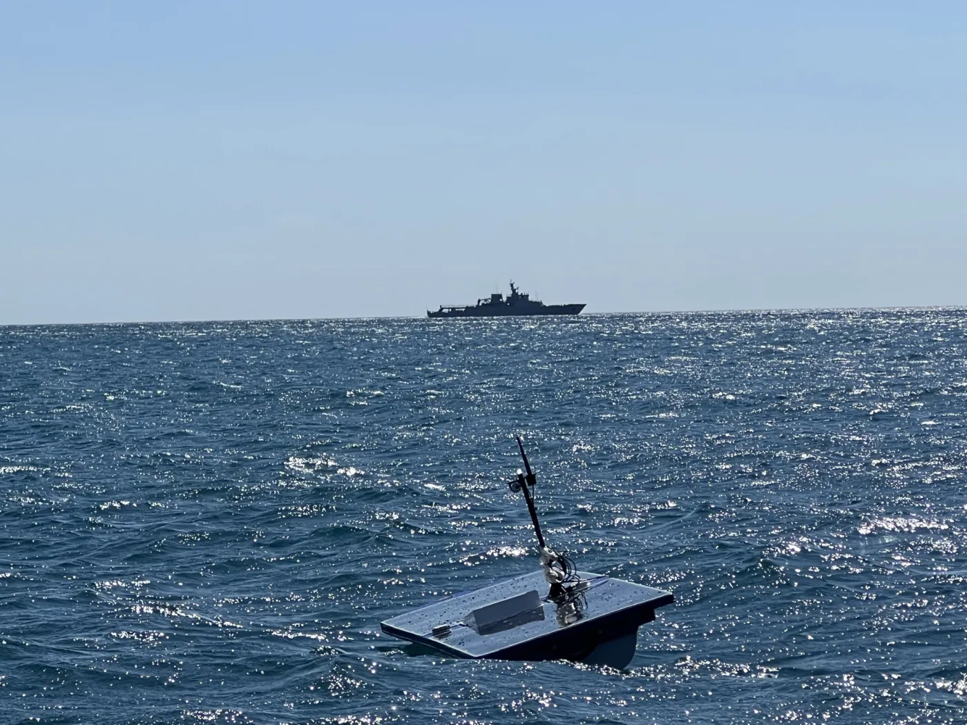 Scout USV holding station in the REPMUS exercise area with a NATO warship astern